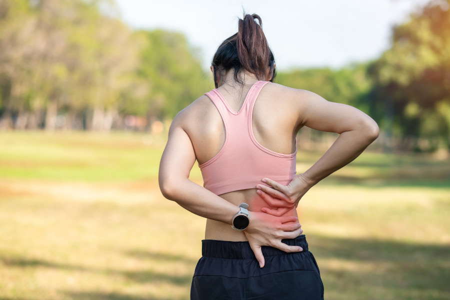 woman clutching her lower back in pain