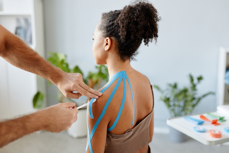 woman having tape applied to her shoulder